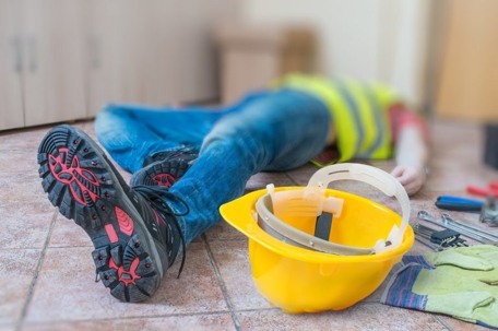 An unconscious worker lying on the floor after a construction accident