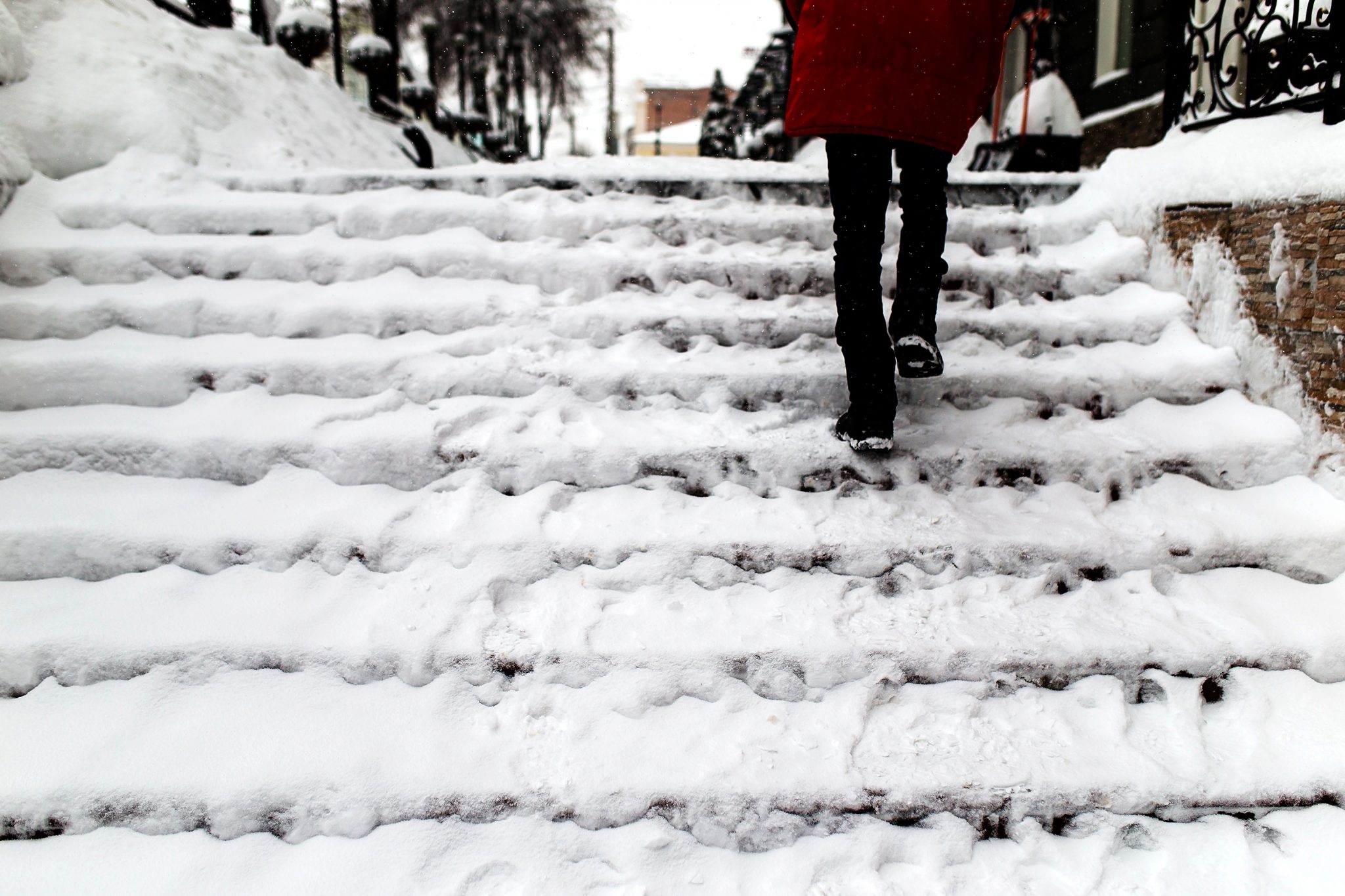 woman walking up snow covered stairs